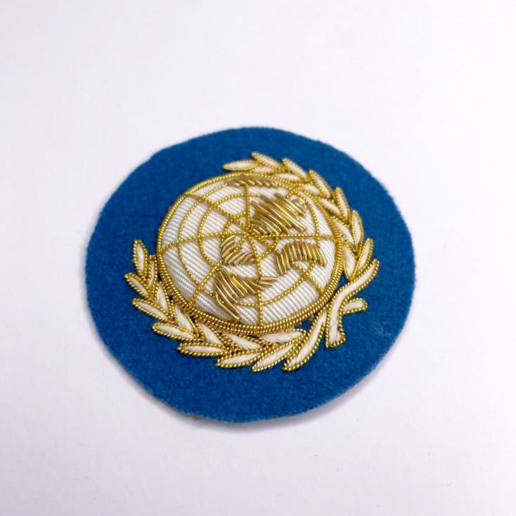 UNITED NATIONS CAP BADGE (4334336344136)